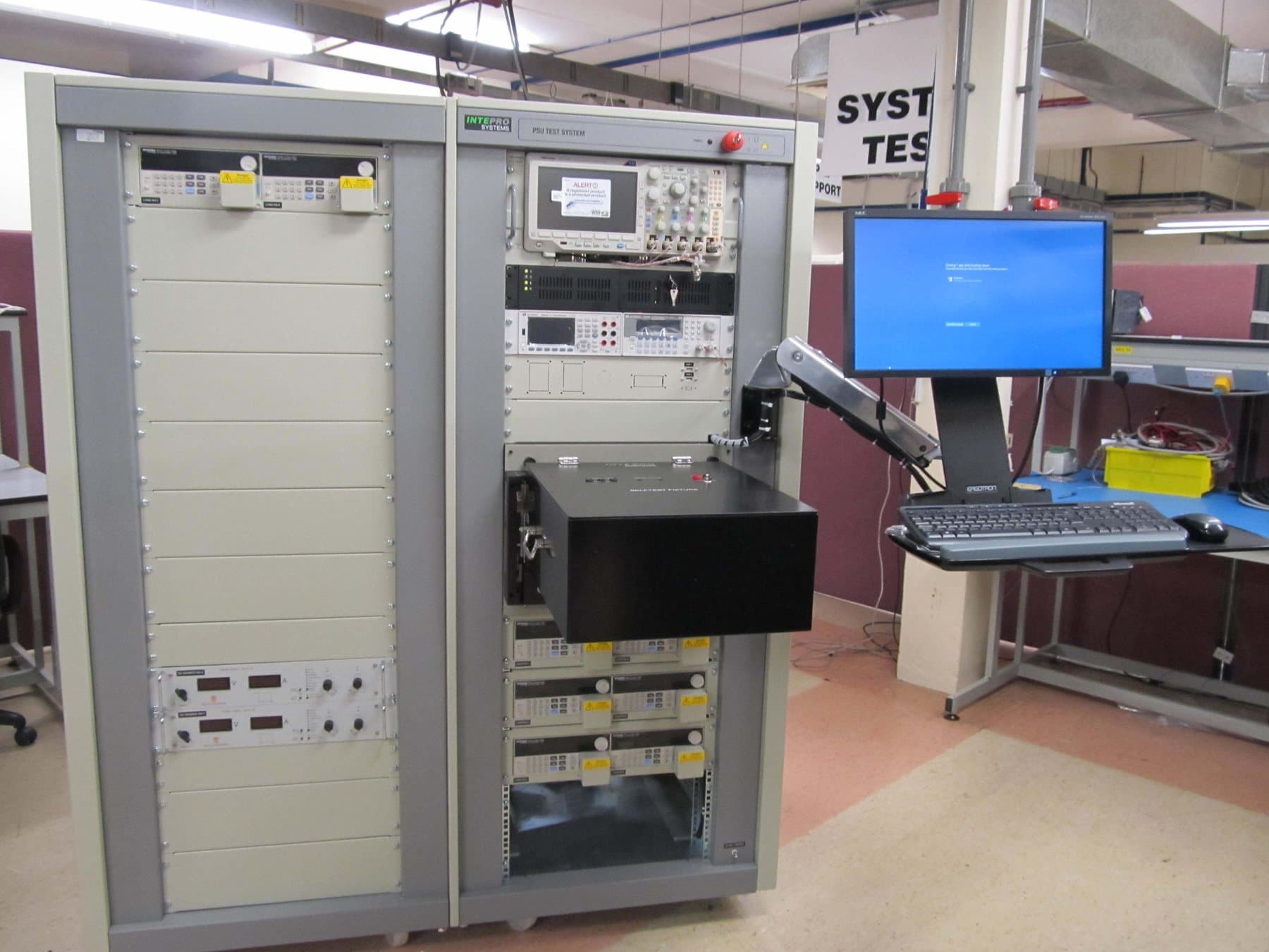 Intepro battery test rack with instrumentation bays and an operator screen on a swing arm